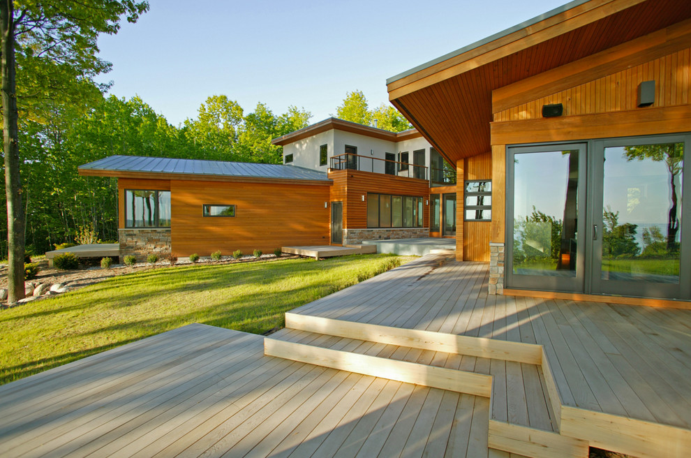 Réalisation d'une grande façade de maison marron minimaliste à un étage avec un revêtement mixte, un toit en appentis et un toit en métal.
