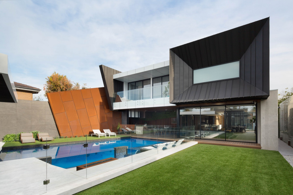 Idées déco pour une façade de maison multicolore contemporaine à un étage avec un revêtement mixte et un toit plat.