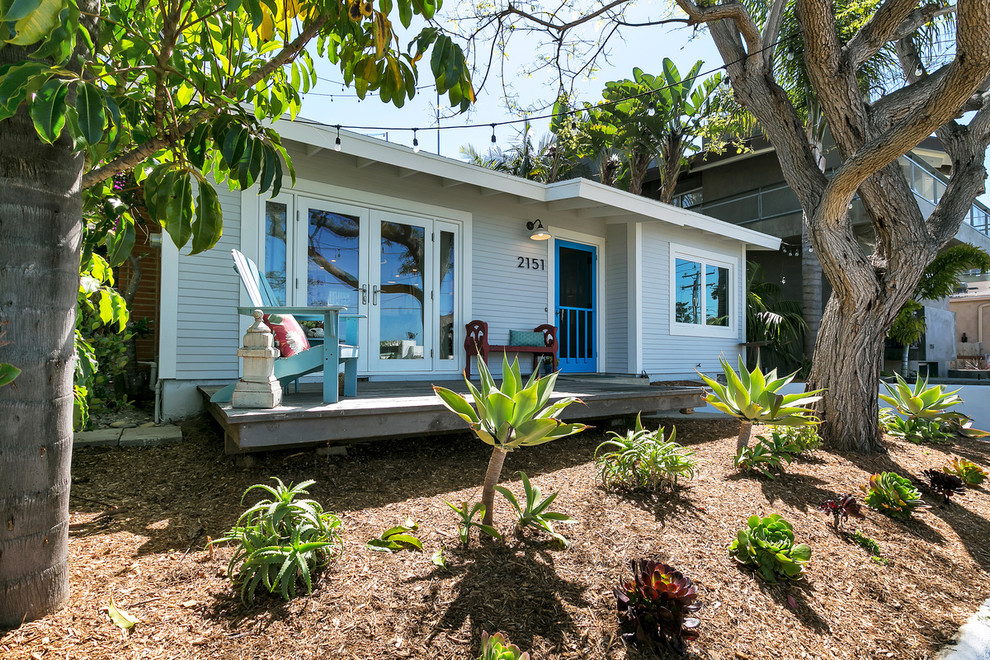 Пример оригинального дизайна: маленький, одноэтажный, серый частный загородный дом в морском стиле с облицовкой из винила для на участке и в саду