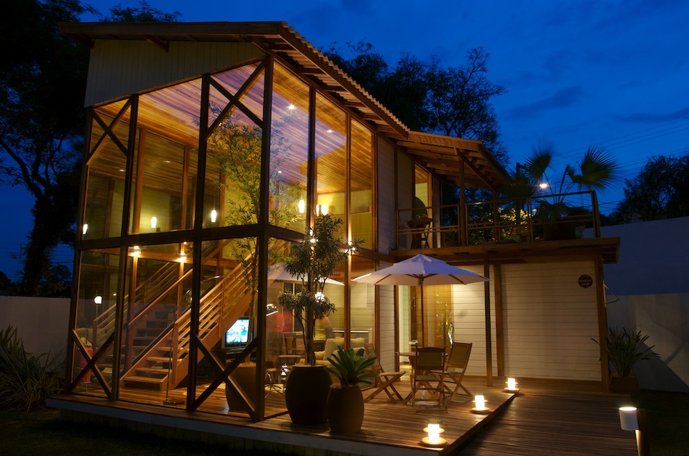 Idee per la facciata di una casa tropicale a due piani con rivestimento in vetro