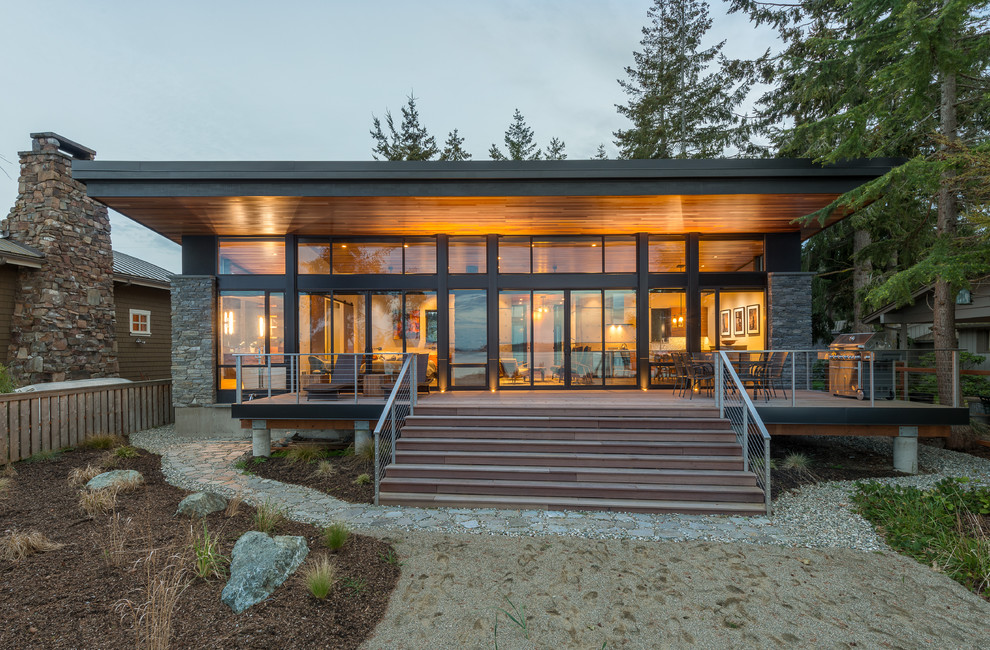 Photo of a small and gey modern bungalow detached house in Seattle with stone cladding, a lean-to roof and a metal roof.