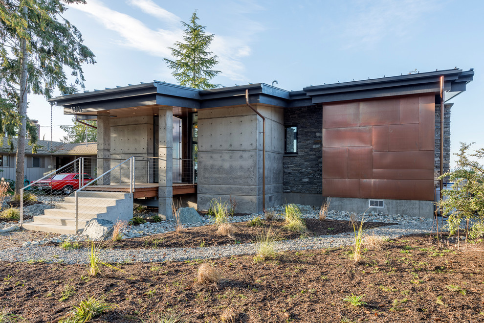 Kleines, Einstöckiges Modernes Einfamilienhaus mit Betonfassade, grauer Fassadenfarbe, Pultdach und Blechdach in Seattle