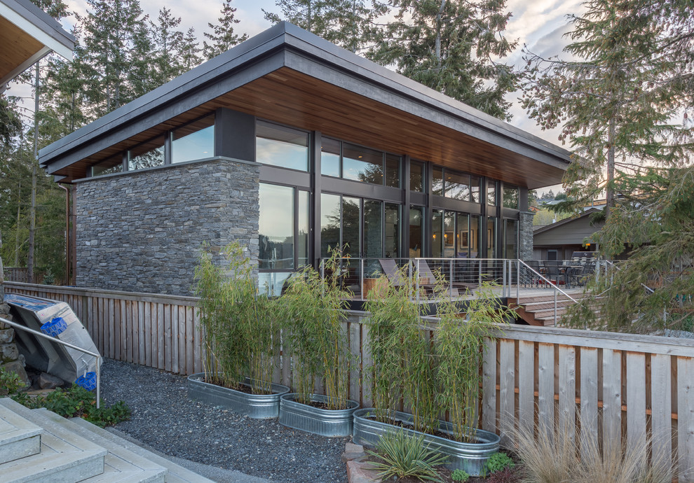 Idee per la facciata di una casa piccola grigia moderna a un piano con rivestimento in pietra e copertura in metallo o lamiera