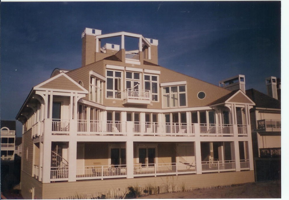 Пример оригинального дизайна: большой, трехэтажный, бежевый дом в морском стиле с комбинированной облицовкой
