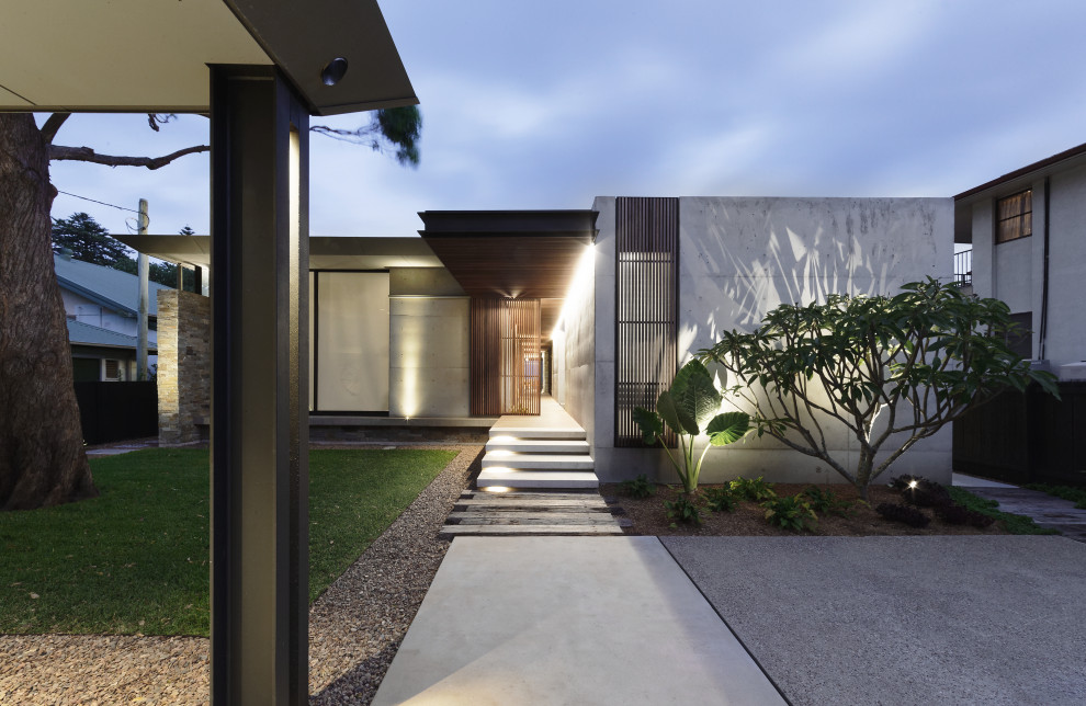 Modelo de fachada de casa gris actual de tamaño medio de dos plantas con revestimiento de hormigón, tejado plano y tejado de metal