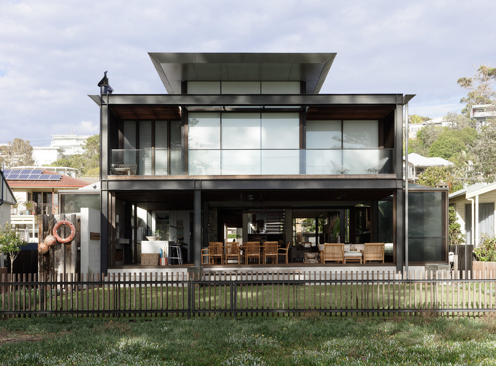 Inspiration för ett mellanstort funkis grått hus, med två våningar, platt tak och tak i metall