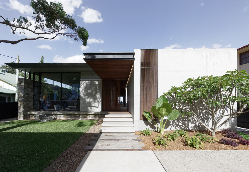 Modelo de fachada de casa gris contemporánea de tamaño medio de dos plantas con revestimiento de hormigón, tejado plano y tejado de metal