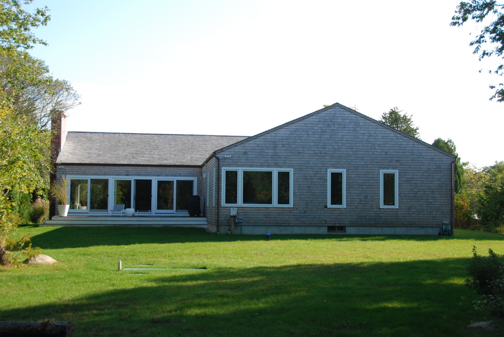 Imagen de fachada de casa beige moderna de tamaño medio de una planta con revestimiento de madera, tejado a cuatro aguas y tejado de teja de madera