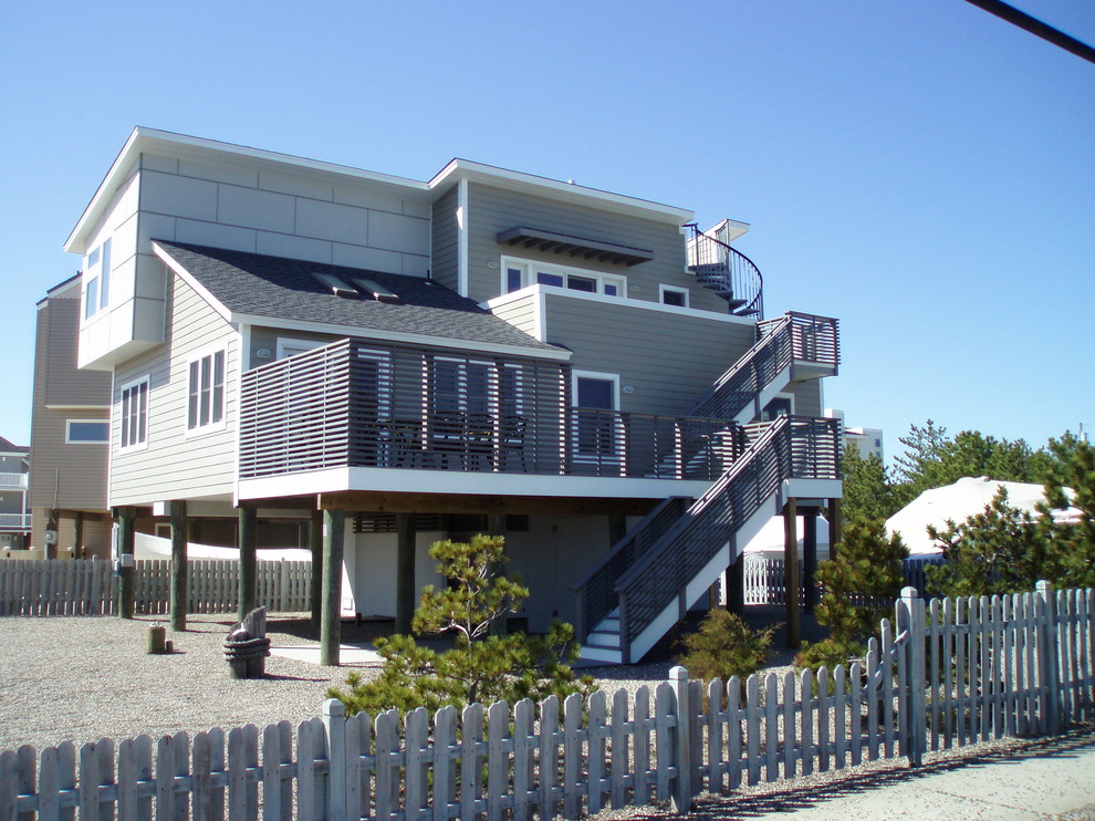 Foto della facciata di una casa grigia stile marinaro con rivestimenti misti