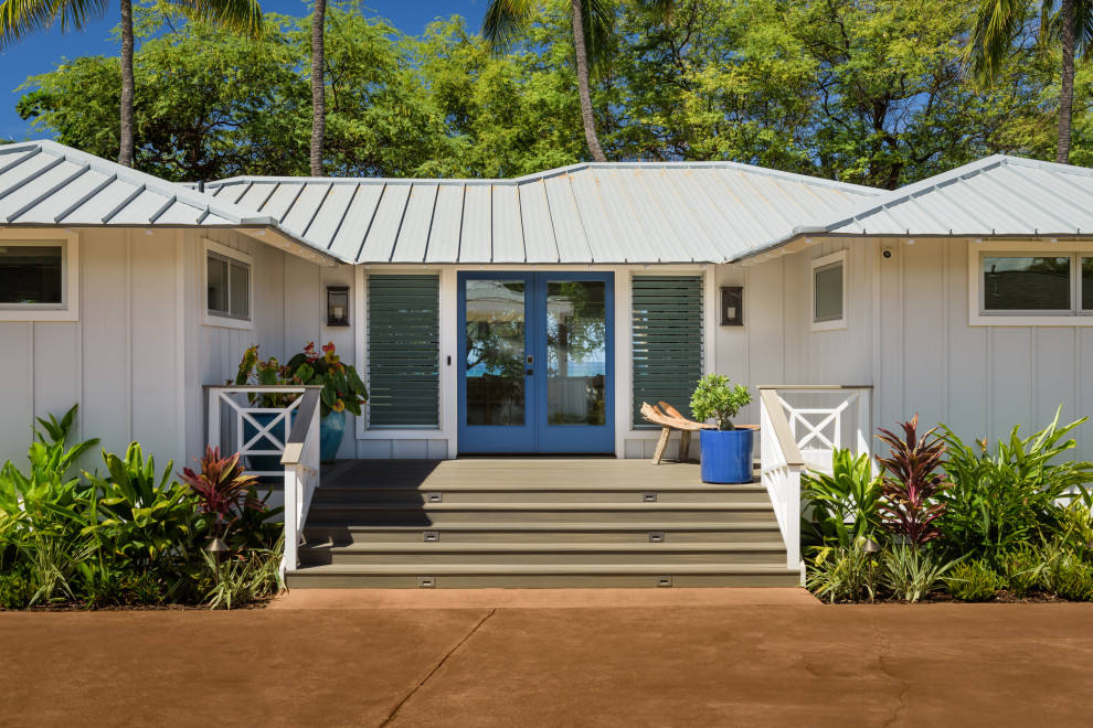 This is an example of a small beach style bungalow house exterior in Hawaii with wood cladding.