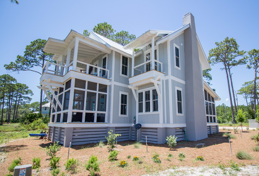 Ejemplo de fachada de casa azul costera de tamaño medio de dos plantas con revestimiento de aglomerado de cemento, tejado a dos aguas y tejado de metal