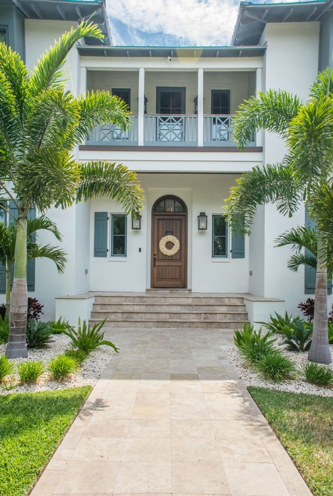 Diseño de fachada de casa blanca tropical grande de dos plantas con tejado de metal y revestimiento de estuco