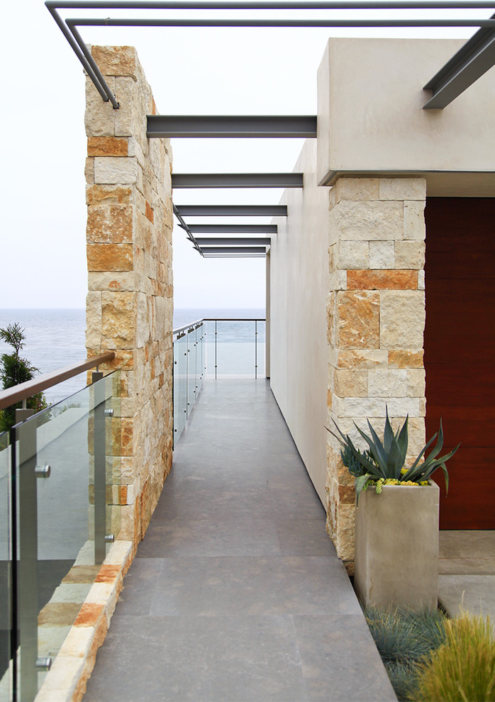 Inspiration for a beach style house exterior in Orange County with stone cladding.
