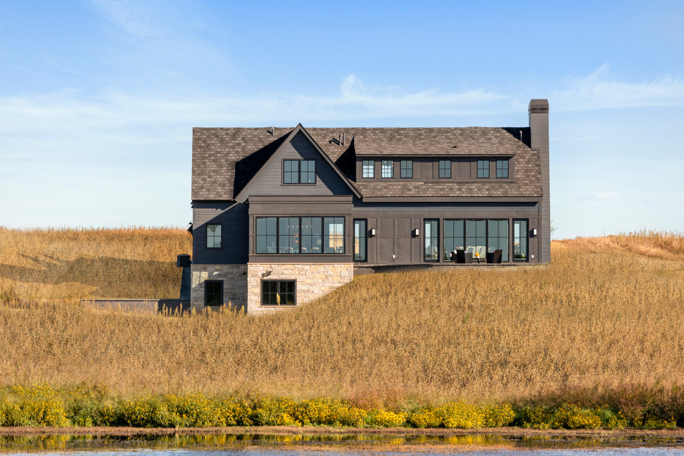 Inspiration pour une grande façade de maison noire marine avec un toit à deux pans et un toit noir.