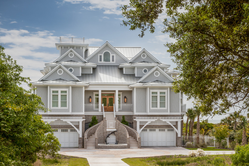 На фото: трехэтажный, деревянный, серый частный загородный дом в морском стиле с металлической крышей с