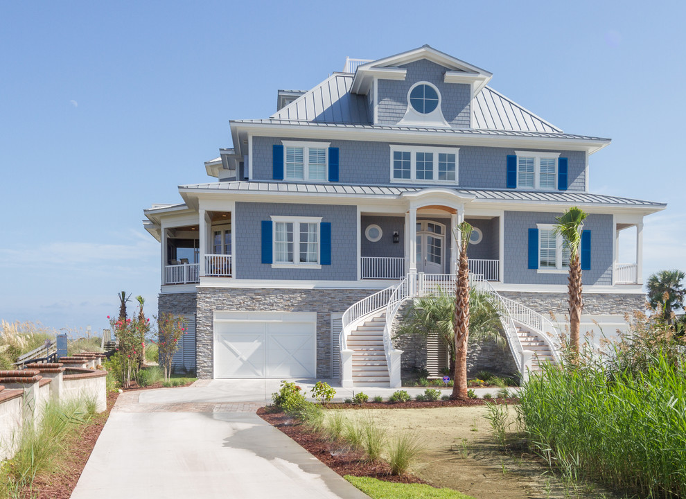This is an example of a blue beach style detached house in Other with three floors, wood cladding, a hip roof and a metal roof.