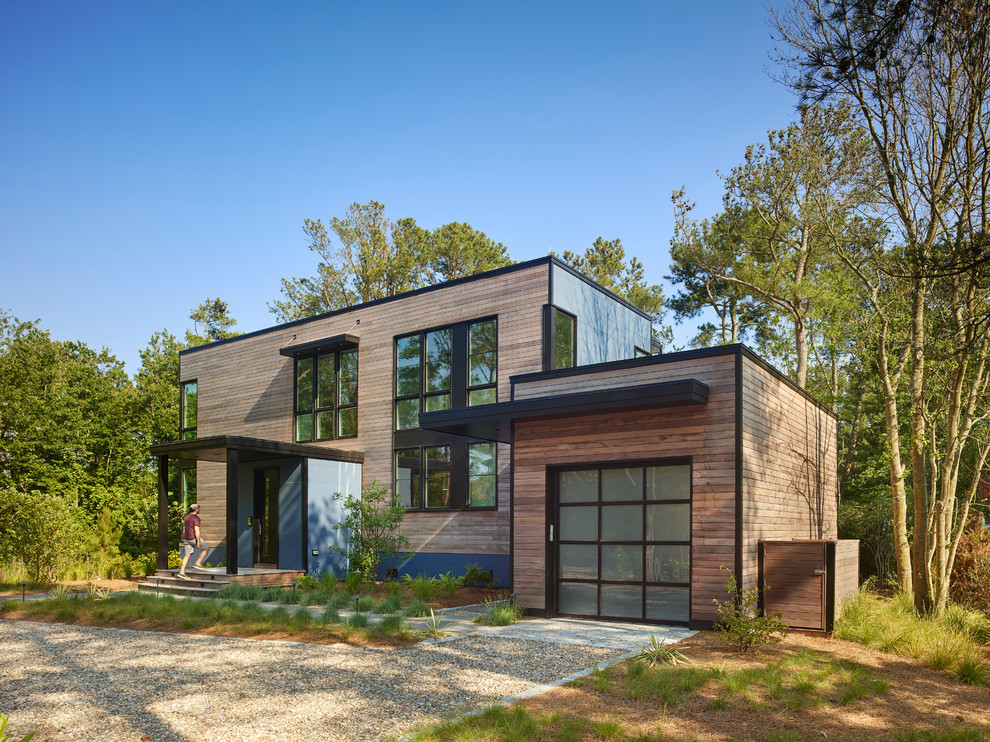 Diseño de fachada de casa costera de dos plantas con revestimiento de madera y tejado plano