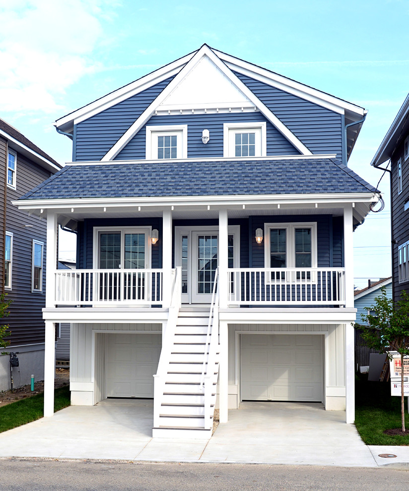 На фото: маленький, двухэтажный, синий дом в морском стиле с облицовкой из винила для на участке и в саду