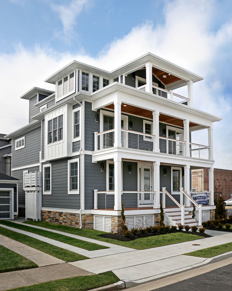 Inspiration pour une façade de maison grise marine en panneau de béton fibré de taille moyenne et à deux étages et plus avec un toit à quatre pans et un toit en shingle.
