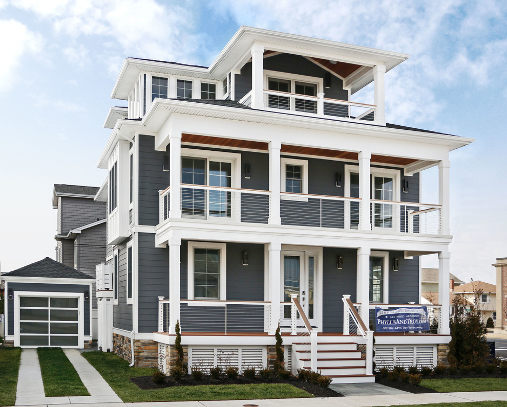 Modelo de fachada de casa gris marinera de tamaño medio de tres plantas con revestimiento de aglomerado de cemento, tejado a cuatro aguas y tejado de teja de madera