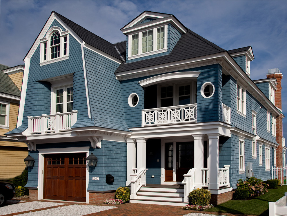 Foto della facciata di una casa grande blu stile marinaro a tre piani con rivestimento in legno e tetto a mansarda