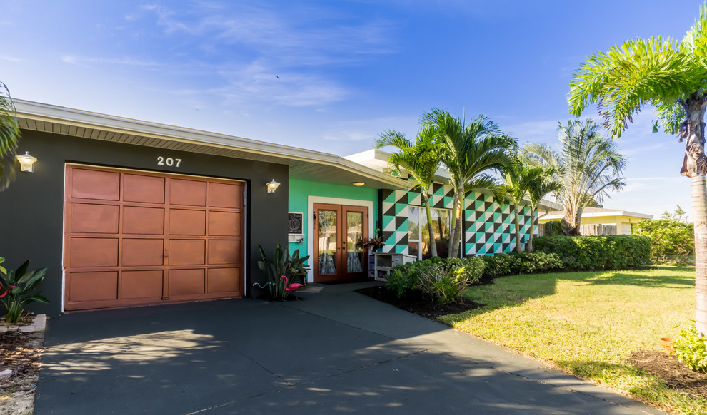 Inspiration for a medium sized and green eclectic bungalow render house exterior in Orlando with a flat roof.