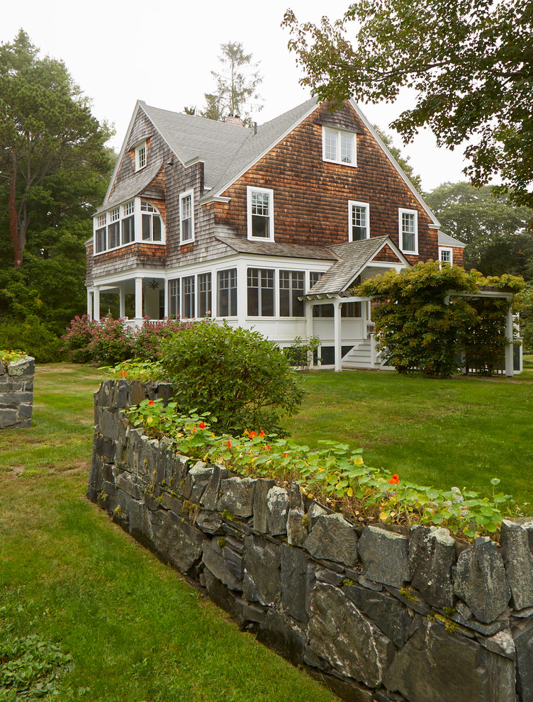 Example of a large beach style brown three-story wood house exterior design in Portland Maine with a shingle roof