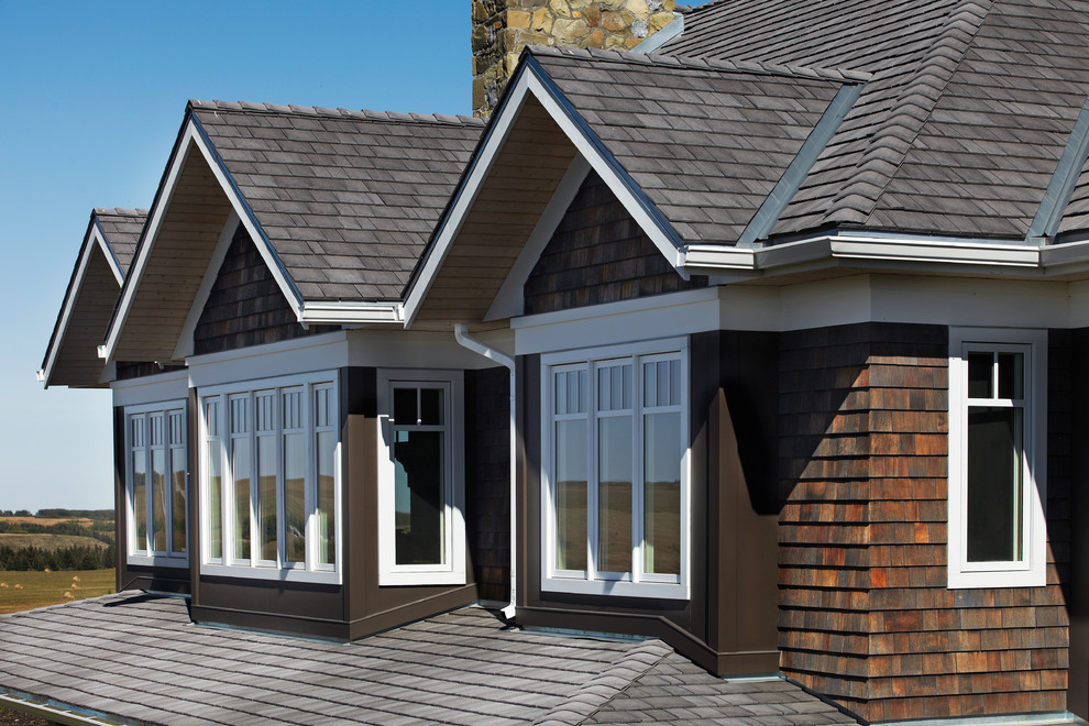 Idée de décoration pour une façade de maison marron craftsman de taille moyenne et à un étage avec un toit à croupette.