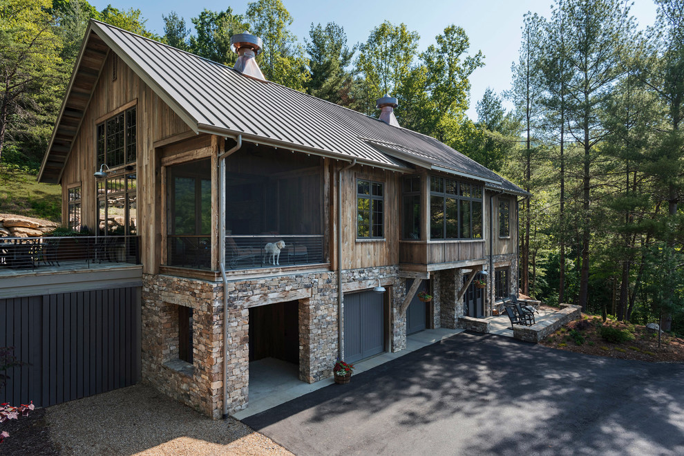 Esempio della villa piccola marrone rustica a tre piani con rivestimento in legno, tetto a capanna e copertura in metallo o lamiera