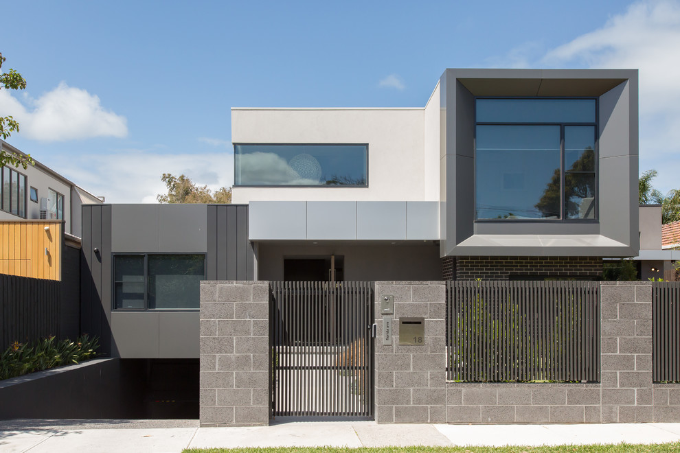 Medium sized and gey contemporary two floor concrete detached house in Melbourne with a flat roof and a tiled roof.