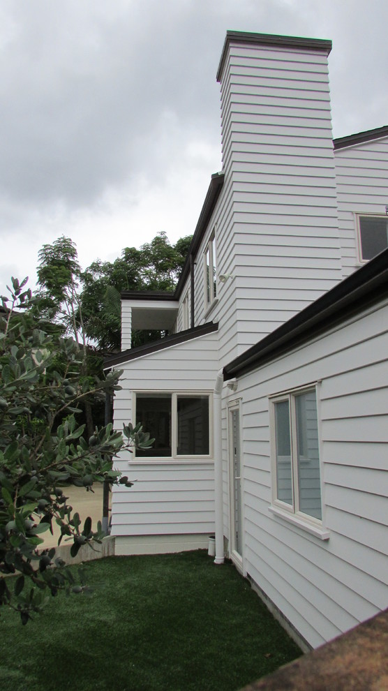 Foto de fachada de casa blanca mediterránea de dos plantas con revestimiento de madera, tejado a dos aguas y tejado de teja de barro