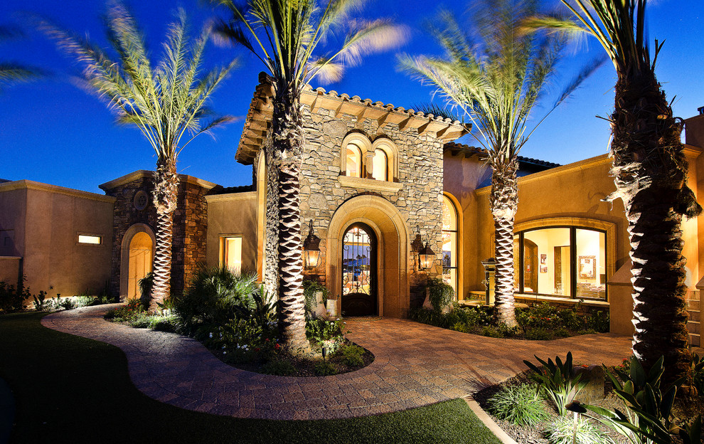 Large tuscan beige two-story stone exterior home photo in Los Angeles with a hip roof