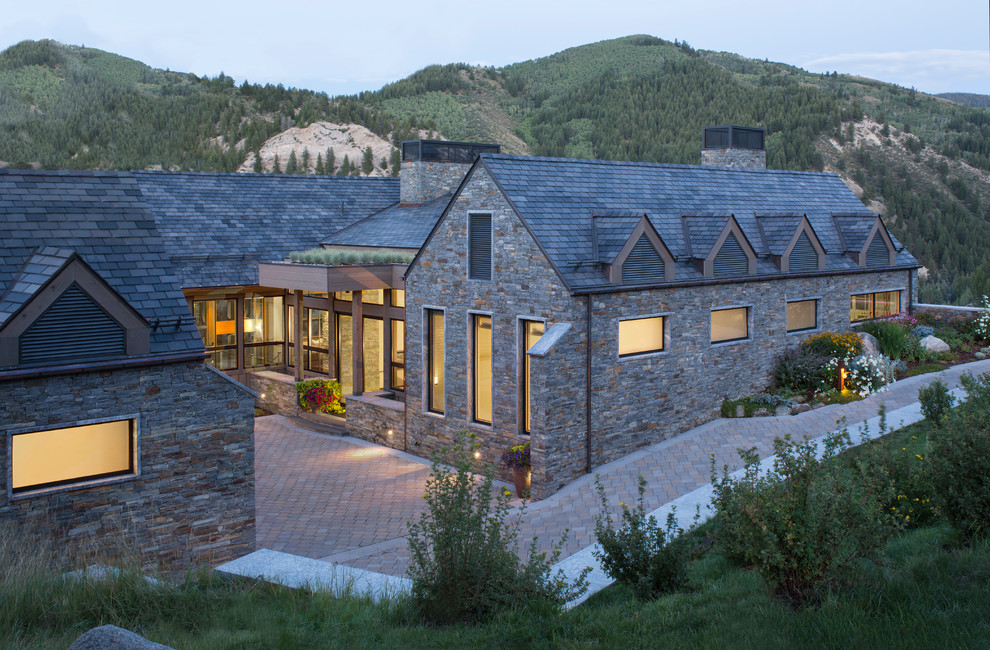 Huge trendy gray three-story stone exterior home photo in Denver