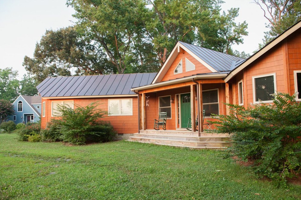 Inspiration pour une façade de maison marron chalet en bois de taille moyenne et de plain-pied avec un toit à quatre pans et un toit en métal.