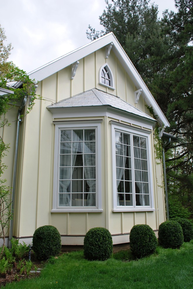 Ispirazione per la facciata di una casa gialla classica a un piano di medie dimensioni con rivestimento in cemento e tetto a capanna