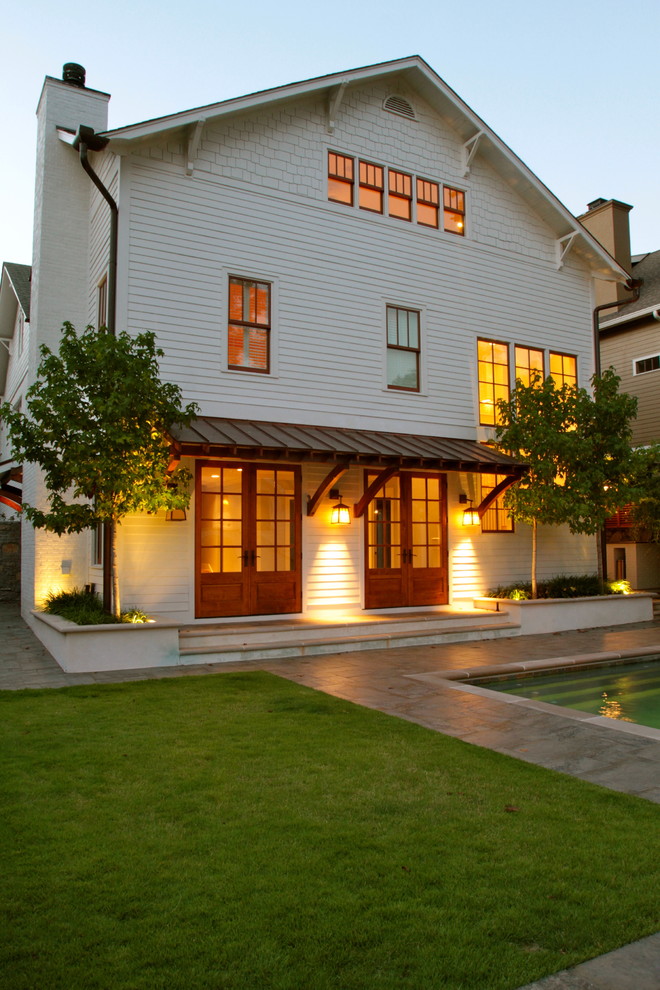 Diseño de fachada blanca clásica de tres plantas con revestimiento de madera y tejado a dos aguas