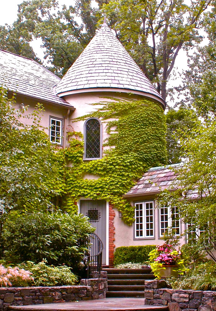 Aménagement d'une façade de maison rose classique à un étage.