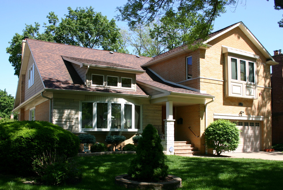 Immagine della facciata di una casa beige classica a due piani di medie dimensioni con rivestimento in mattoni e tetto a capanna