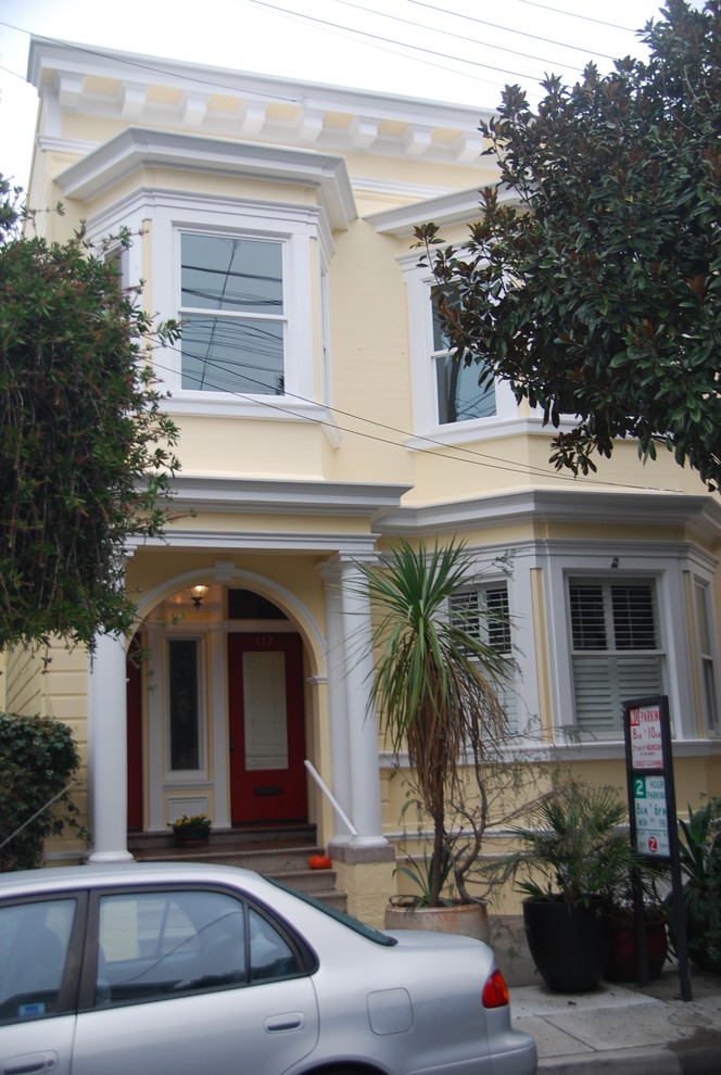 Zweistöckiges Rustikales Haus mit gelber Fassadenfarbe und Flachdach in San Francisco