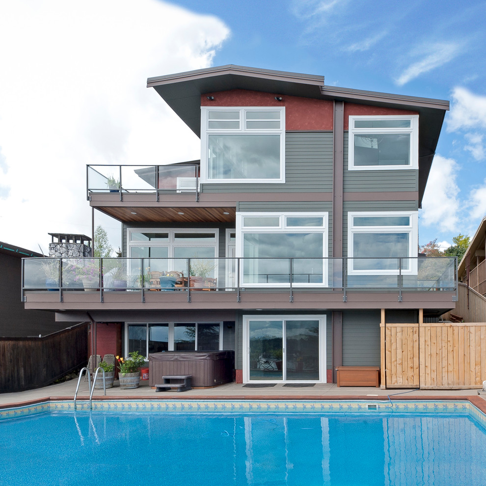 Photo of a large and green nautical house exterior in Seattle with three floors and wood cladding.