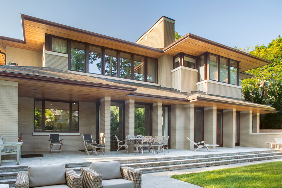 Idee per la facciata di una casa beige contemporanea a due piani di medie dimensioni con rivestimento in mattoni e tetto piano