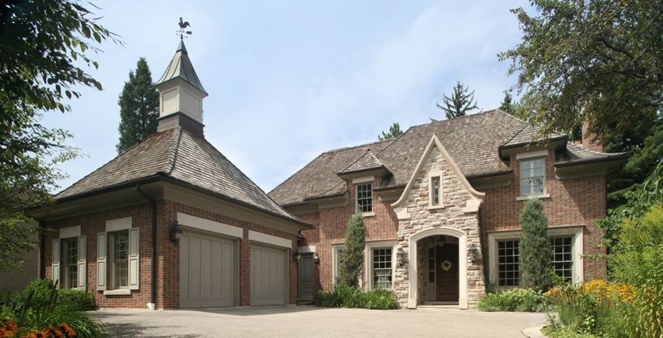 Photo of a large and red classic two floor brick house exterior in Toronto with a hip roof.