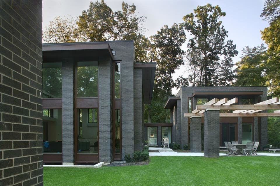 Exemple d'une grande façade de maison noire tendance en brique à un étage avec un toit plat.