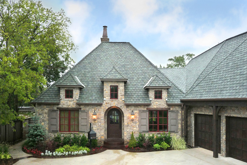 This is an example of a medium sized and beige rustic two floor house exterior in Oklahoma City with stone cladding.