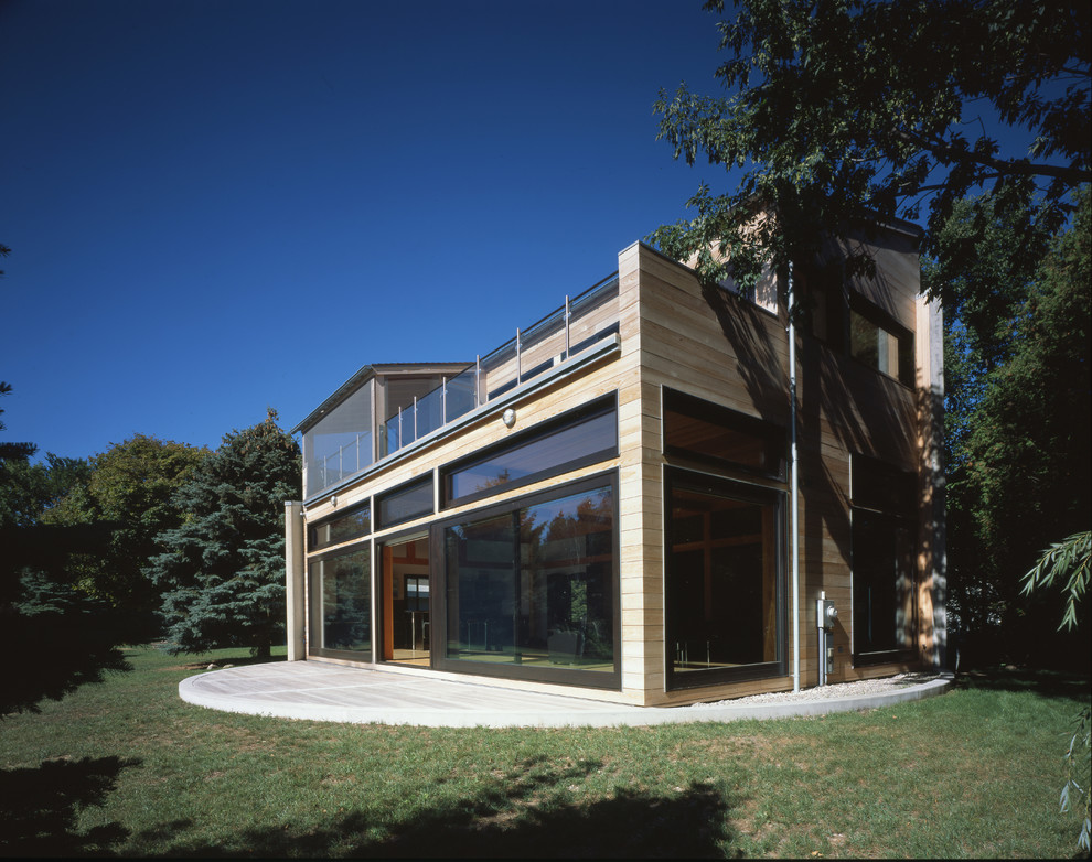 Imagen de fachada de casa moderna pequeña de dos plantas con revestimiento de madera y tejado a la holandesa