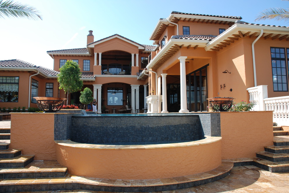 Inspiration for a large mediterranean two-story stucco gable roof remodel in Orlando