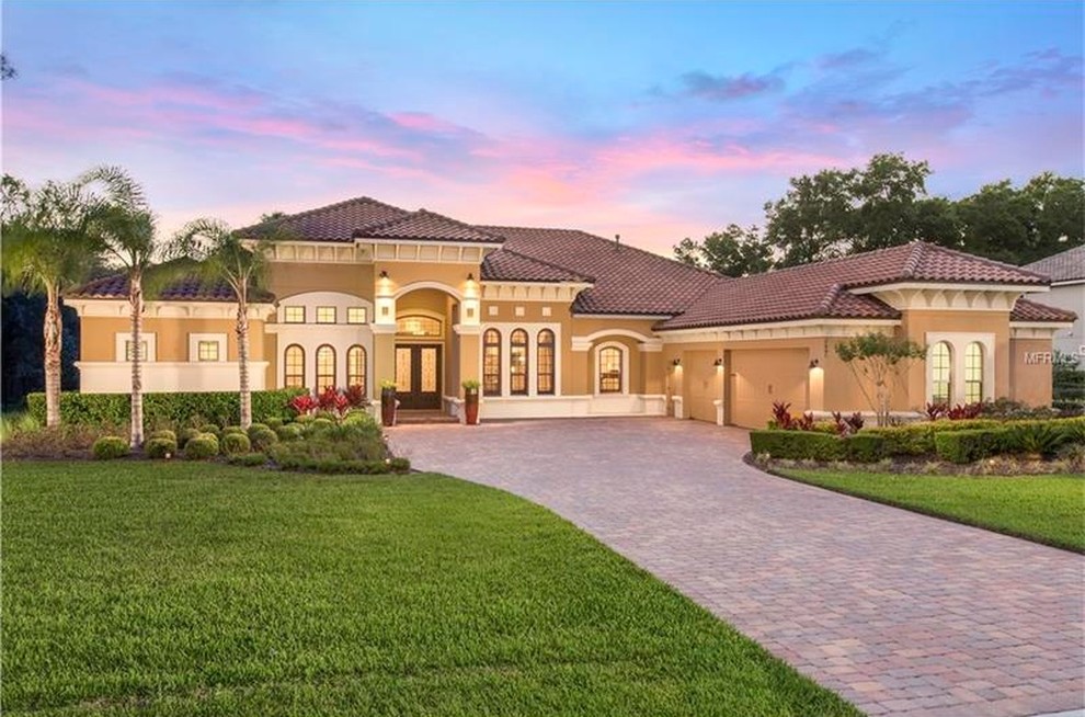 Large and beige traditional bungalow render house exterior in Orlando with a hip roof.