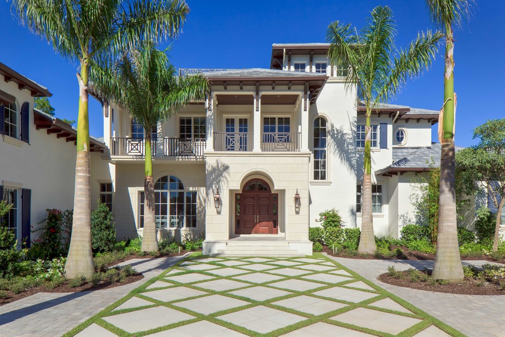 Inspiration for a tropical beige two-story exterior home remodel in Miami