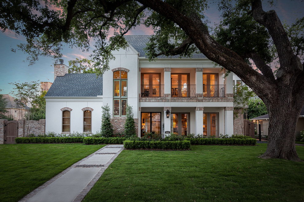 Inspiration for a large timeless white two-story stucco exterior home remodel in Houston