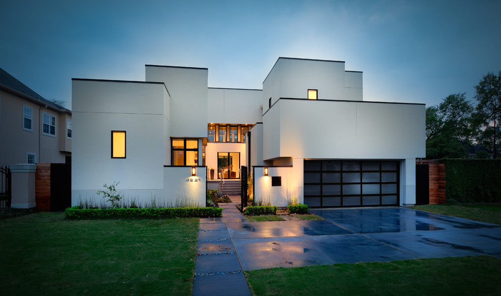Cette image montre une grande façade de maison blanche minimaliste en stuc à un étage avec un toit plat.